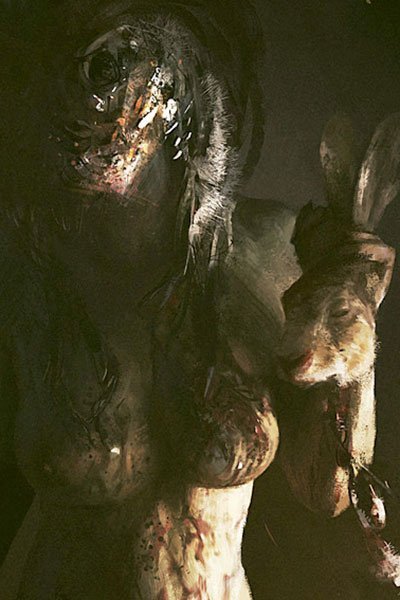 A naked gore-covered woman holds a rabbit's head by the ears.